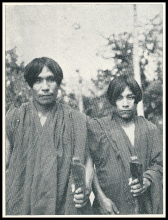 2 young tribal
            South-American jungle-types in robes, holding indigenous
            tools