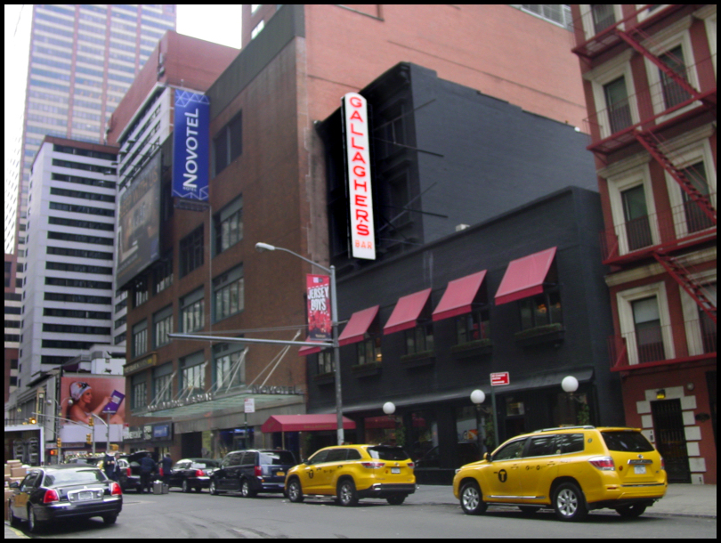 black two-storey Gallagher's
              Steak House with red awnings surrounded by New York
              skyscrapers