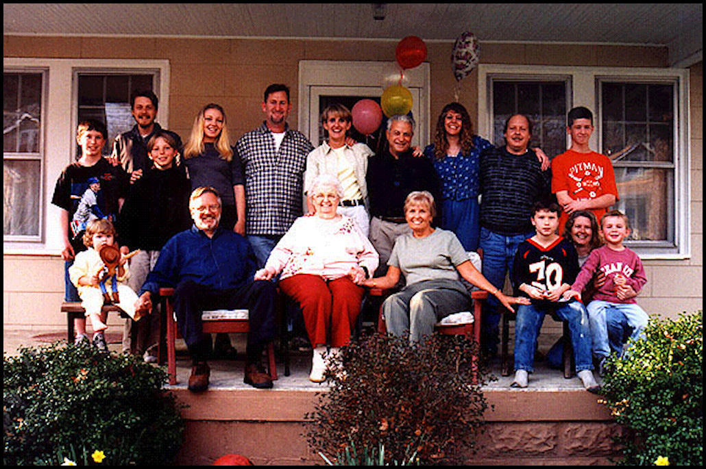 large extended 4-generation
              gringo family on front porch with shrubbery and daffodils