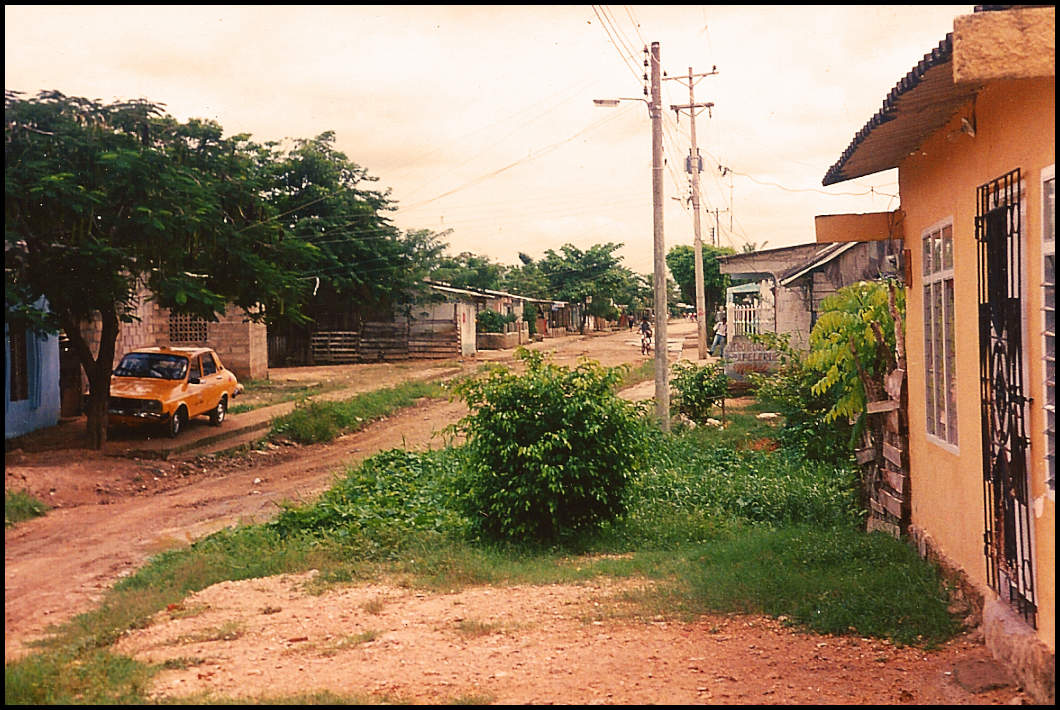 rudimentary houses and dirt
              street empty but for shiny new yellow cab