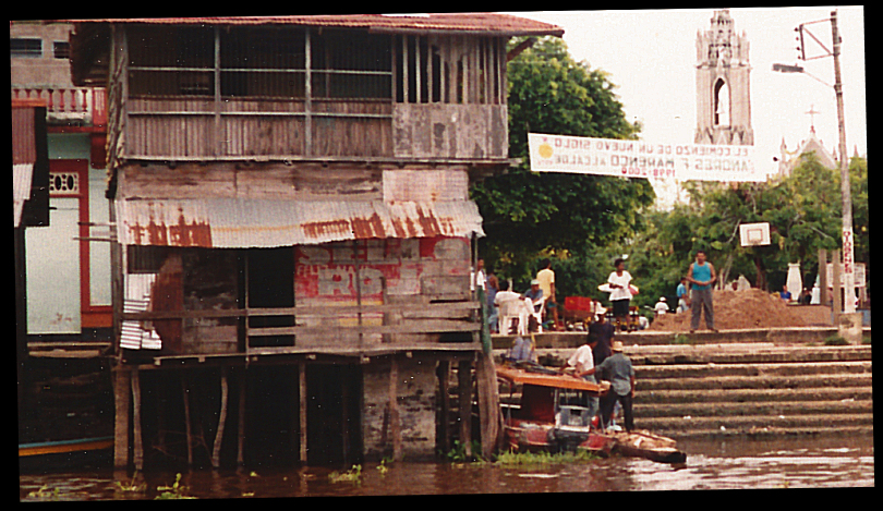 unpainted, rain-
            and flood-beaten, all-wood establishment at docks with
            rusted tin awning, all riased on pilings above flood-prone
            river