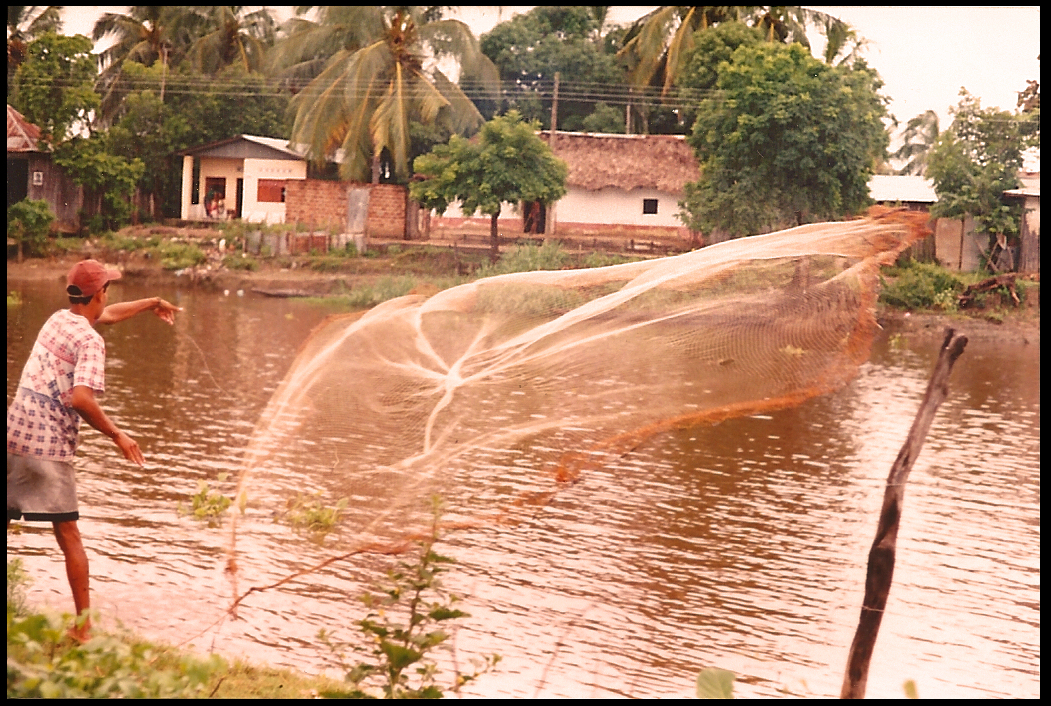 teenage barber-fisherman
              tosses Old World circular fishnet in the Rio Mojana