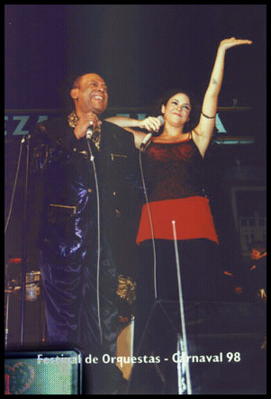 Joe somebody with singer Shakira
              waving from stage during the nighttime Festival de
              Orquestas