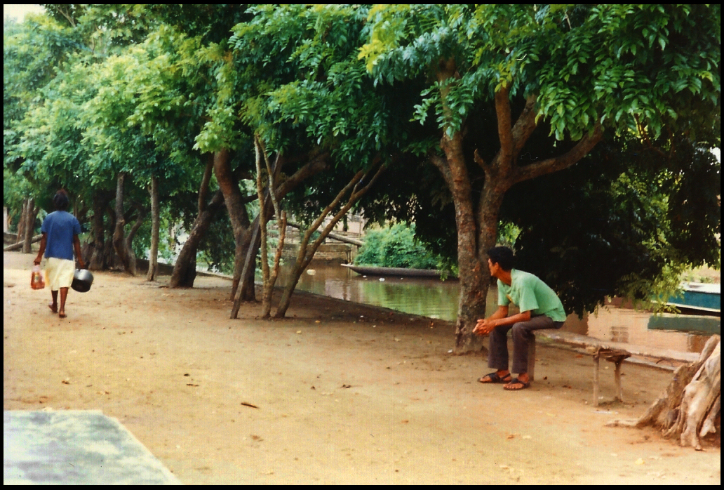 nneighborhood men's bench at the house
          next door to Yazmín's, plus canal with dugout canoe of
          hollowed-out tree trunk, taken by the Dr. from her porch where
          he wrote so much of this diary