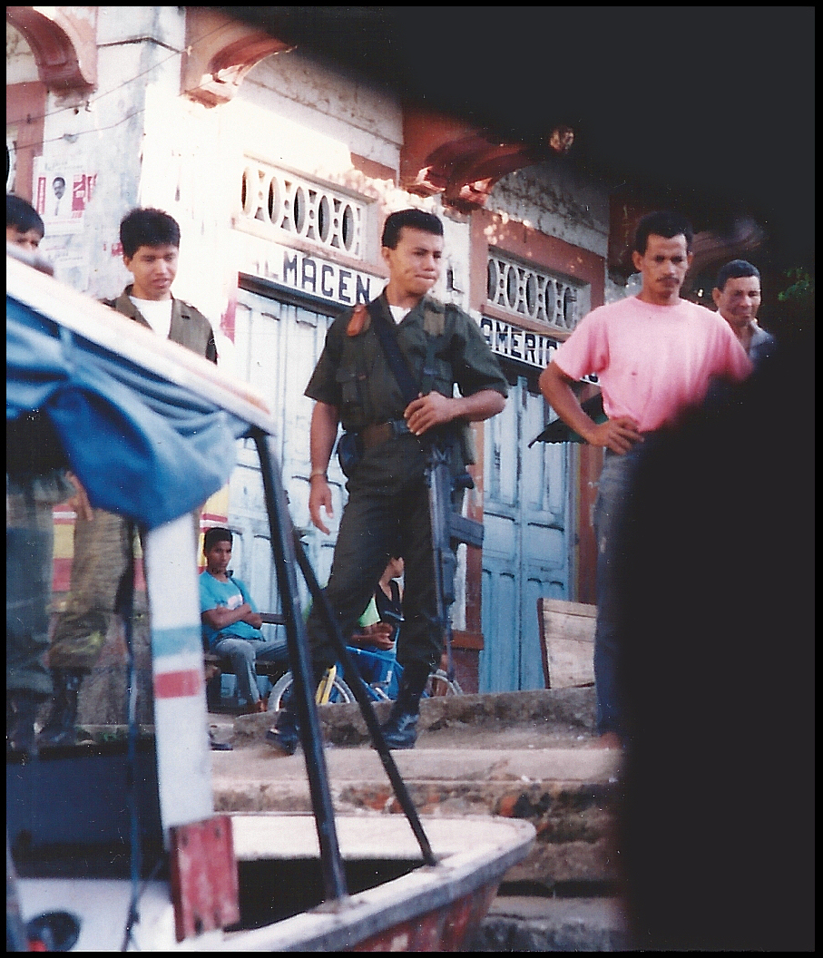 government soldier guards Santisima
              Cruz main dock surrounded by local men