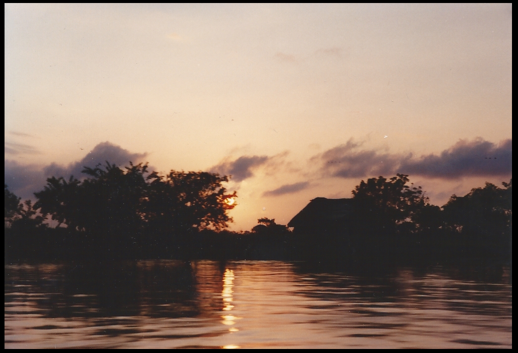 orange and purple sky and
              rippling river with thatch-rooved house