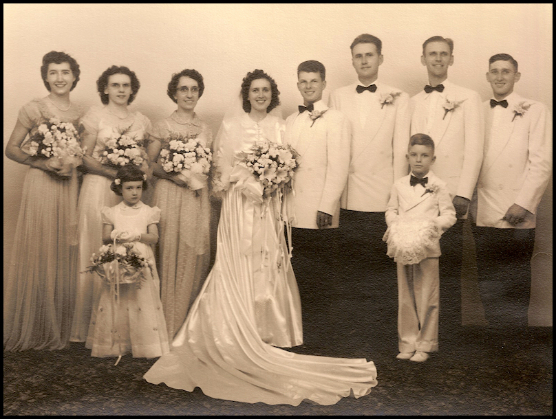 black and white professional photo of
              a 1950 wedding party with flower girl and little boy ring
              bearer