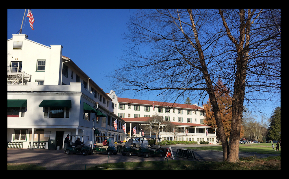 well-cared-for,
              3-winged, 4-story white inn with red roof and golf carts