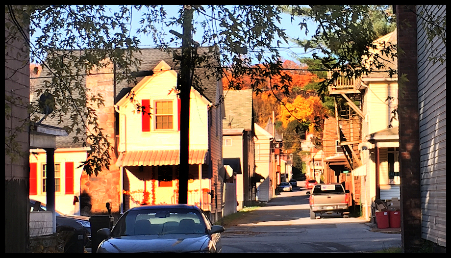 tall early 20th
              century houses packed in around an alley in Tyrone, Pa.,
              Fred Waring's birth town, caught in early morning sunlight
              in fall, with tree color