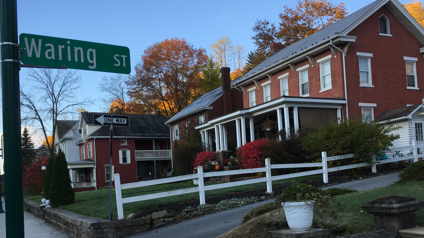 big red brick houses in a row on a hill cut
                by an alley whose street sign reads 'Waring St'