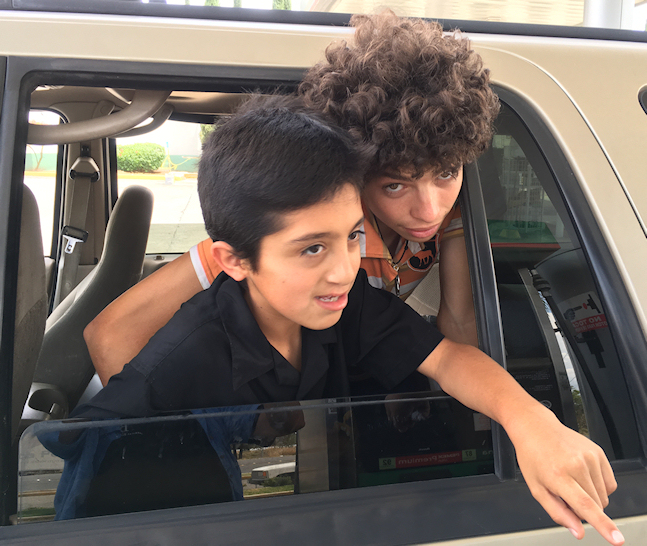 Arn, 13, and
        Chuchn, 20, in rear window of Dr. Lorenzo's world-famous 2000
        Expedition