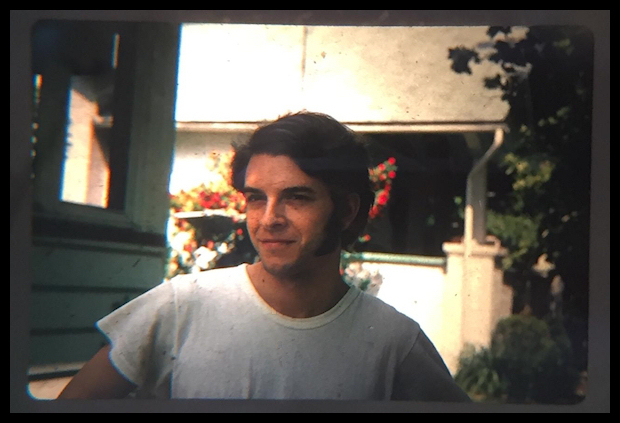 young Dr.
              Lorenzo in a white T-shirt with long sideburns